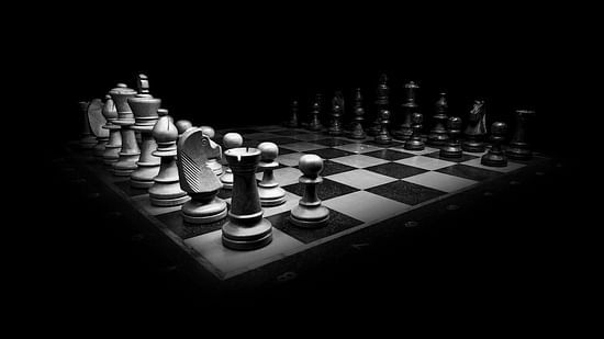 a chessboard with chess pieces set up for a game, illuminated against a dark background
