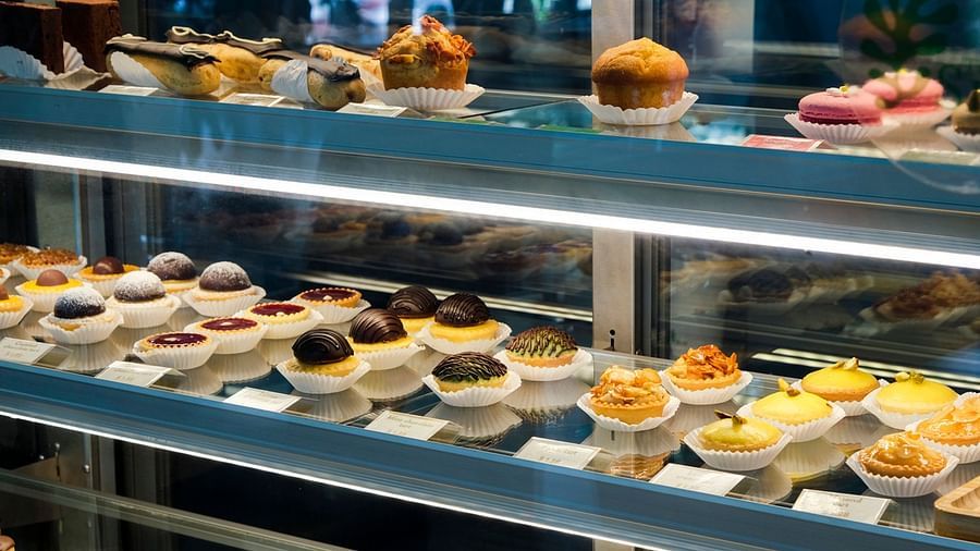 A glass display case is filled with various pastries and desserts | The Shop | Central Mansions, Phnom Penh