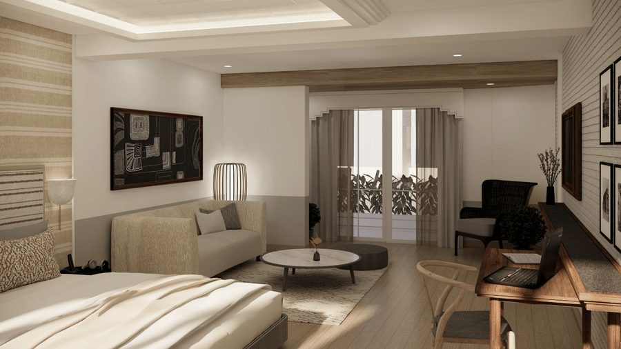 A suite containing a bed with a striped headboard, a beige sofa, a round coffee table, and a desk with an open laptop at Shilton Suites, Benglauru.