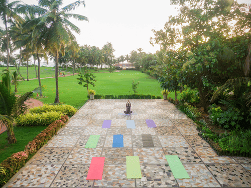 image of a tiled pavement with expansive green lawns at the far end of the image at kenilworth resort and spa, goa