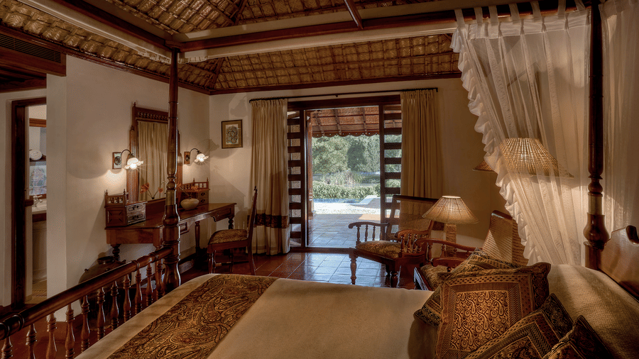 Spacious luxury heritage-style Pool Villa Bedroom with canopy bed at Evolve Back Coorg