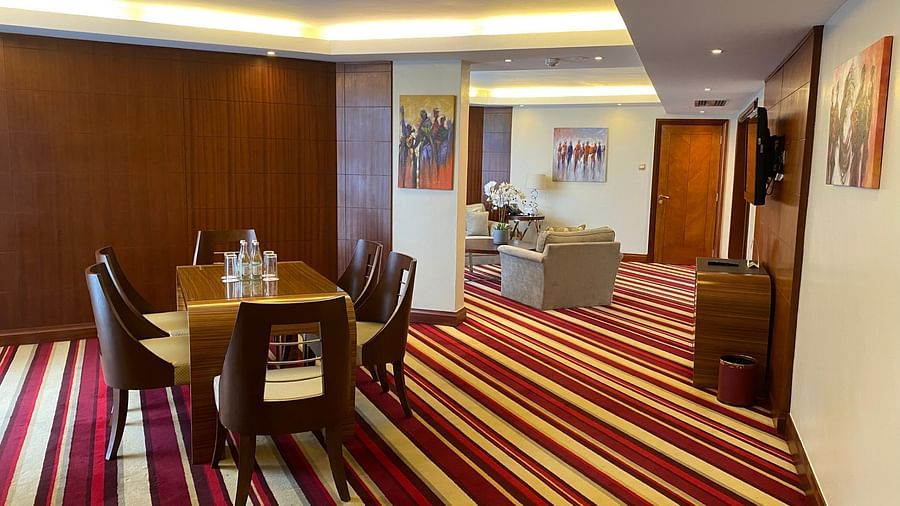 Sitting area with chairs surrounding a table and stripe carpet at The Boma Nairobi.