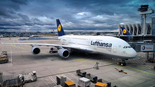 A Lufthansa airplane in the airport with dark clouds in the background