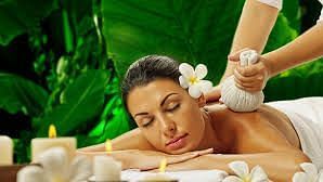 Image of a woman lying on flat surface with plants in the background at Parampara Resort & Spa, Kushalnagar.