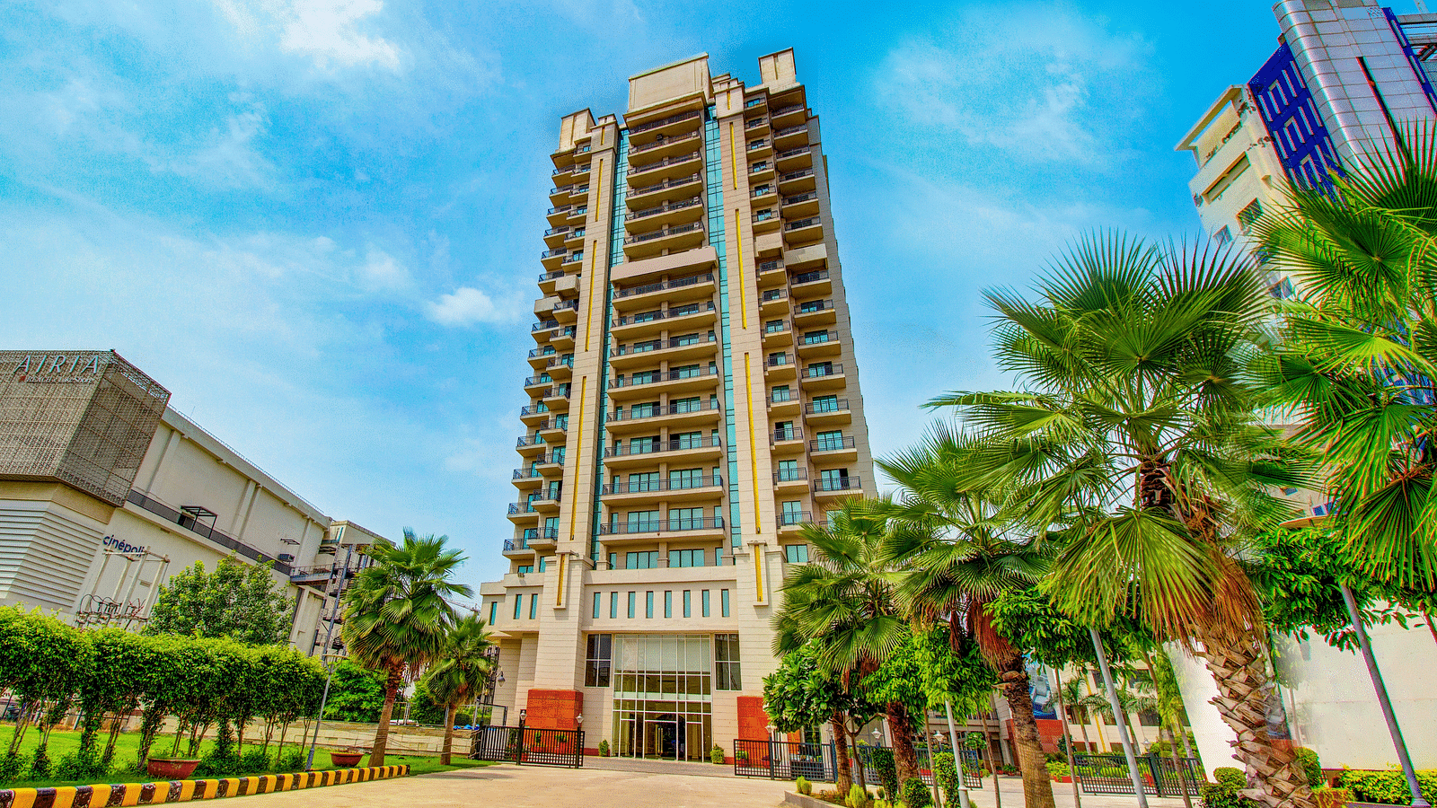 Facade view of the Entrance with trees in view at Rhythm Gurugram.