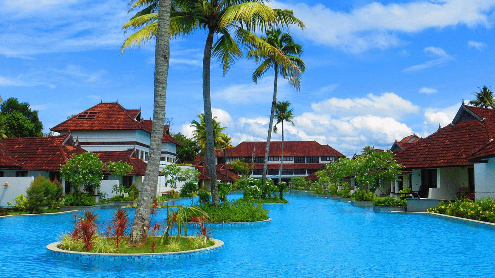 an image of a swimming pool with rooms and trees in view - Rhythm Kumarakom
