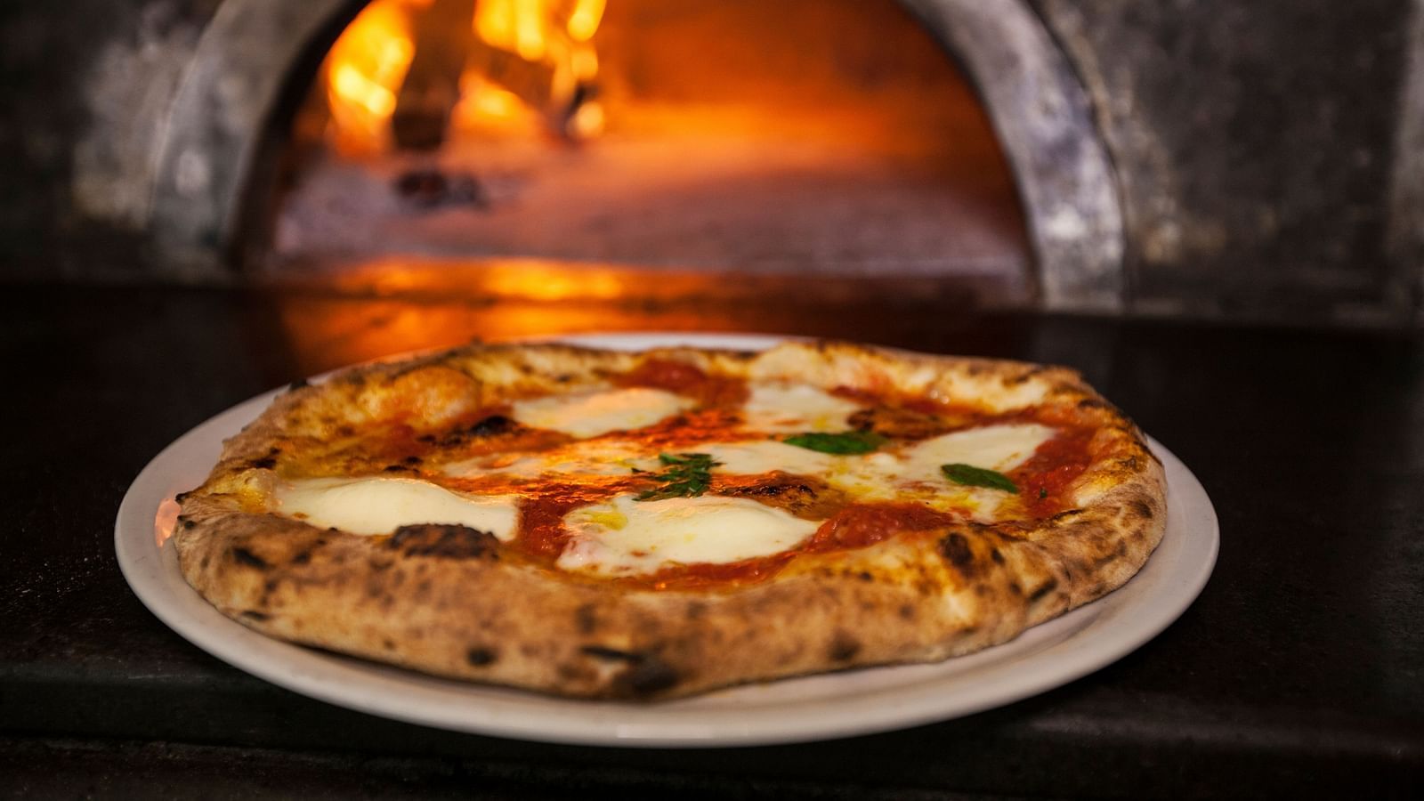  A delicious-looking pizza served on a plate - Rhythm Lonavala