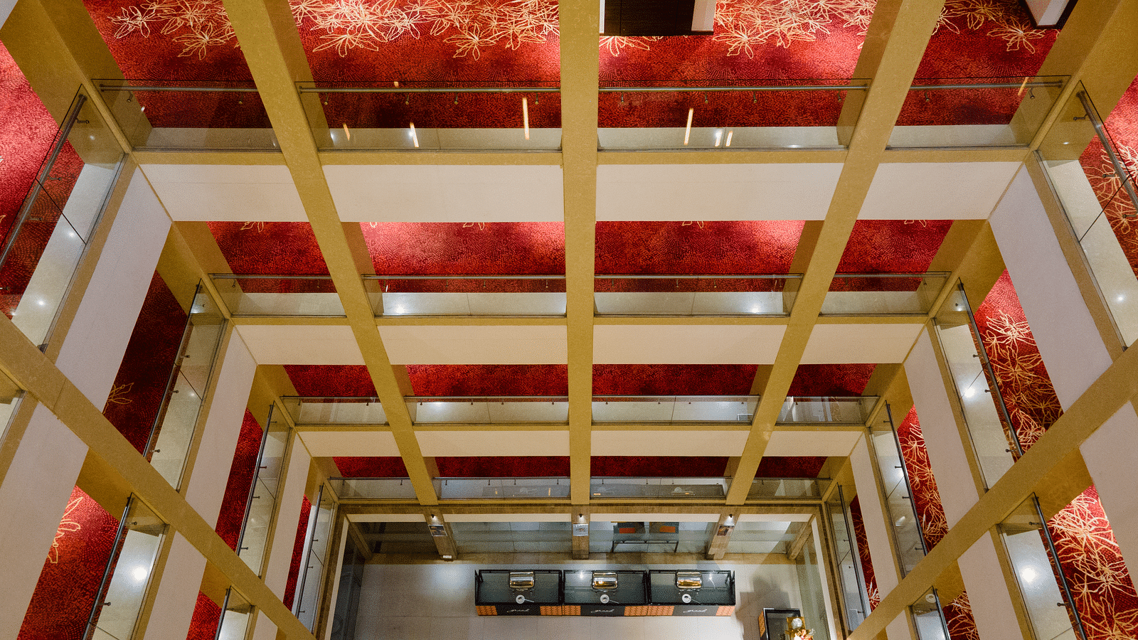 A long shot view of corridors covered with red mattress at Grand Kakinada by GRT Hotels