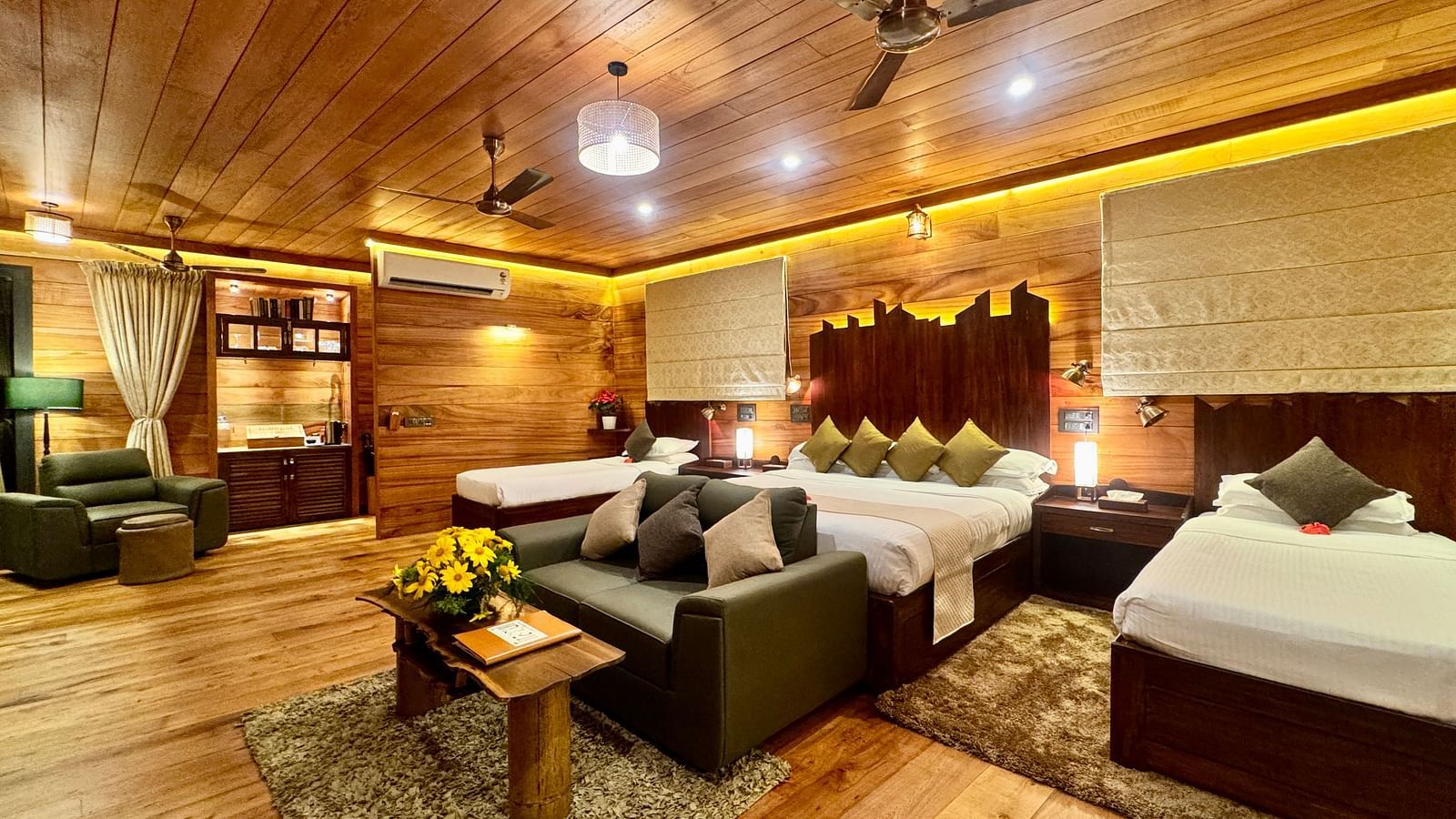 A warm room featuring a double bed, armchairs, a small table, and wooden panelling - BluSalzz Collection - Tranquil Resort, Wayanad