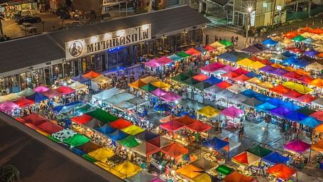 an aerial view of a night market with many shops and people in view.