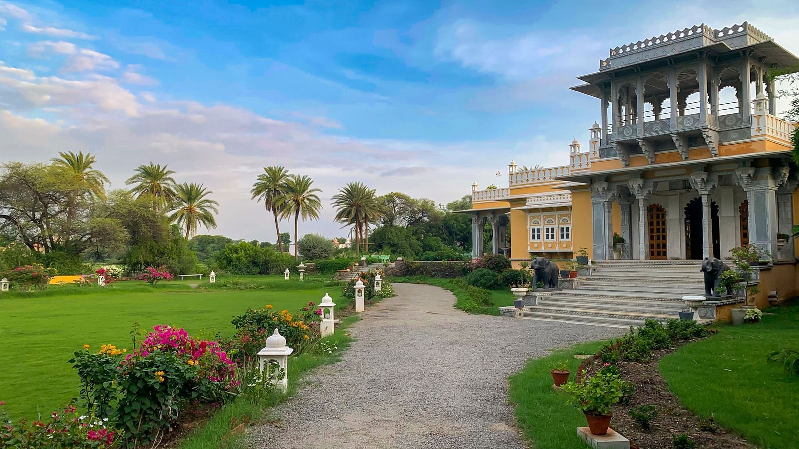 a tranquil Facade image of Dev Shree, Deogarh with a beautiful green lawn in the foreground