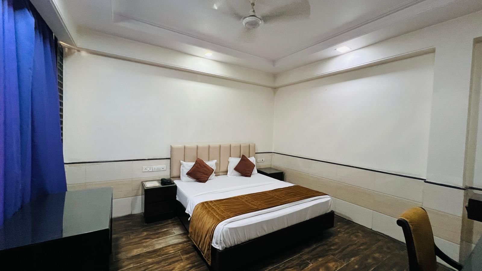  stylish hotel suite featuring a comfortable bed, an ornate rug, and ample space, perfect for a restful stay. | Suite | Hotel Aadhar