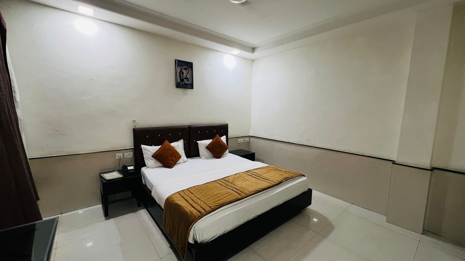 A compact hotel room with a bed and simple, functional furnishings