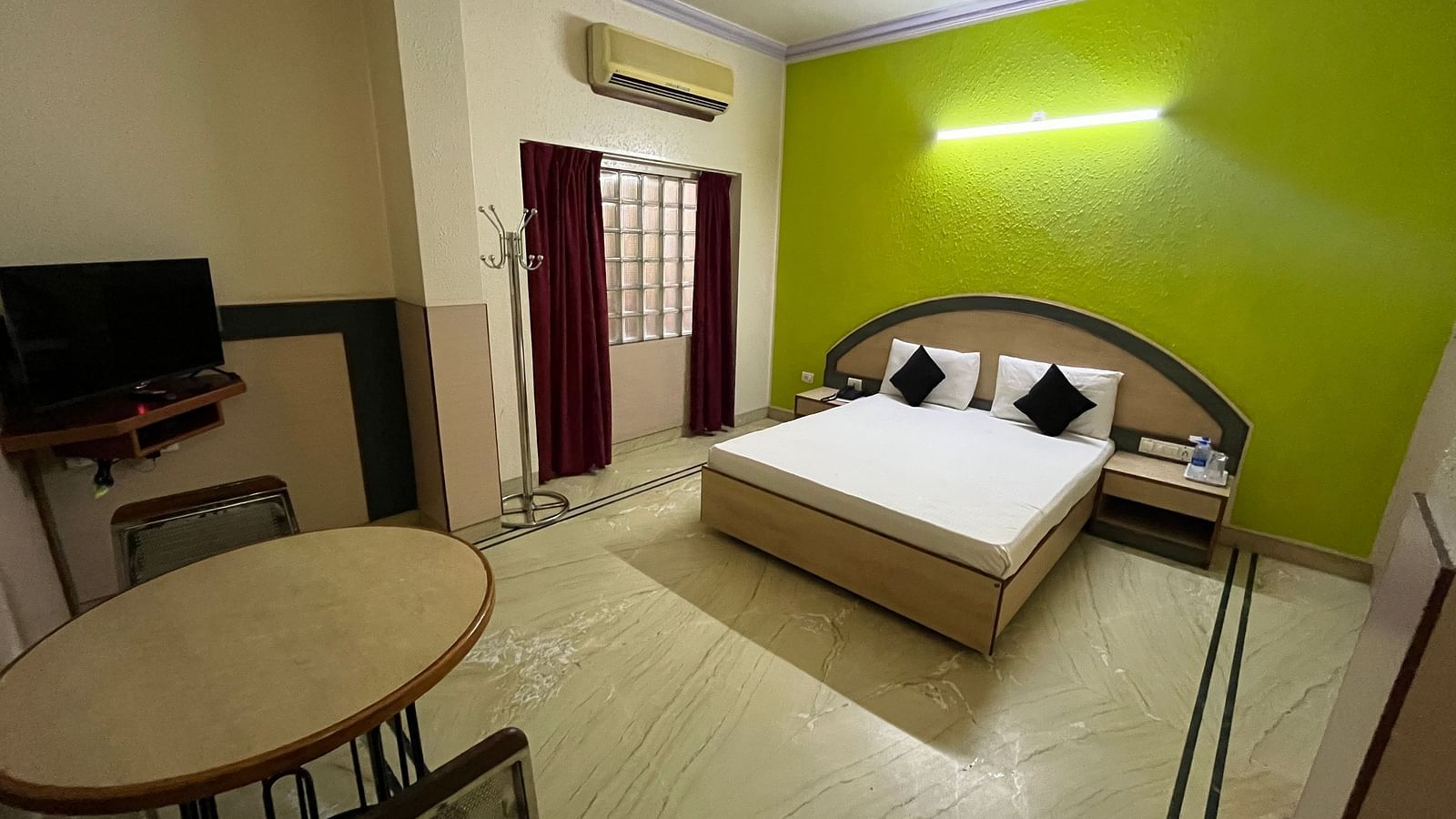 full view image of the standard room with a dining area and a double bed at The Grand Krishna Rooms, Bengaluru