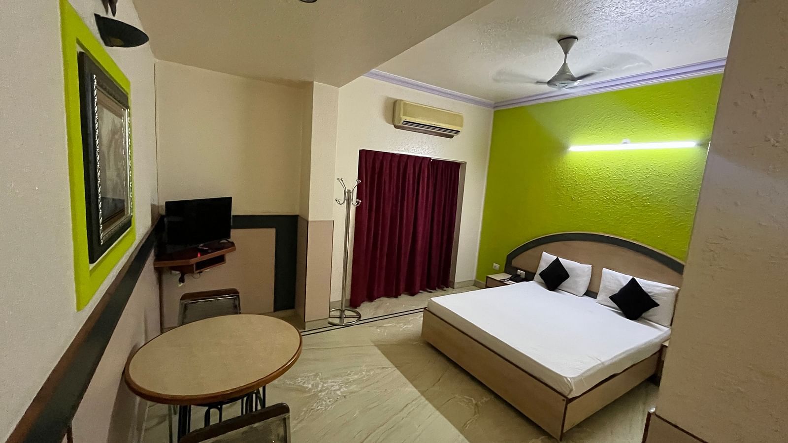 image of the standard room featuring a dining table right opposite the double bed at The Grand Krishna Rooms, Bengaluru