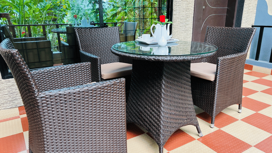 Image of an outdoor seating area with three chairs and a table in between at Coorg Jungle Camp Backwater Resort, Kushalnagar.