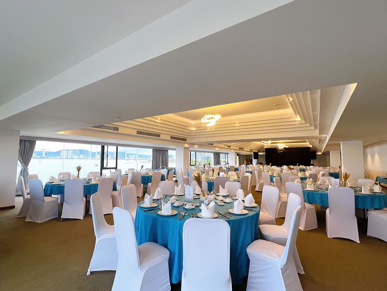 Blue round tables with chairs in front of them in our Panorama Hall - Alibu Resort