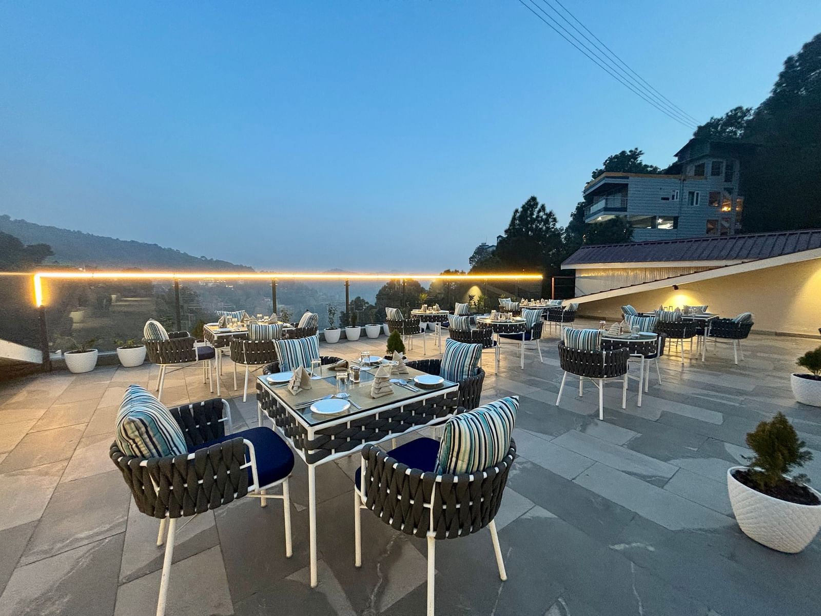 Outdoor dining area at twilight with neatly arranged tables and scenic views – ARNISA Boutique Hotel