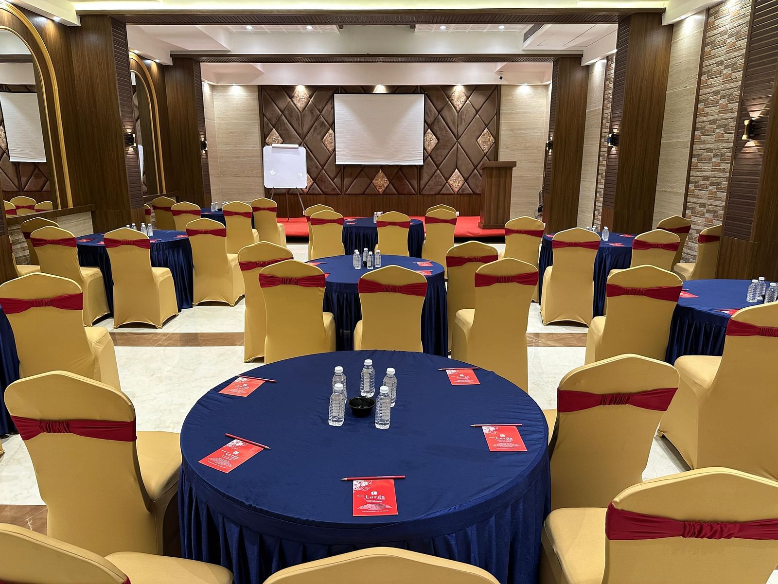 A large meeting room with a round table and chairs, set up for a professional gathering - Lords Hotels & Resorts