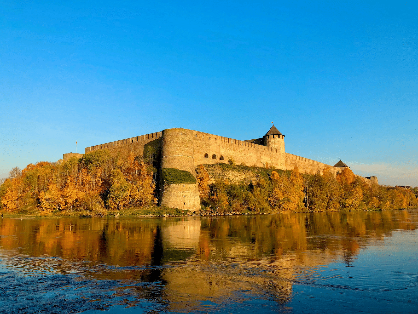 A brown building on top of a building infront of a water body qhkd9r
