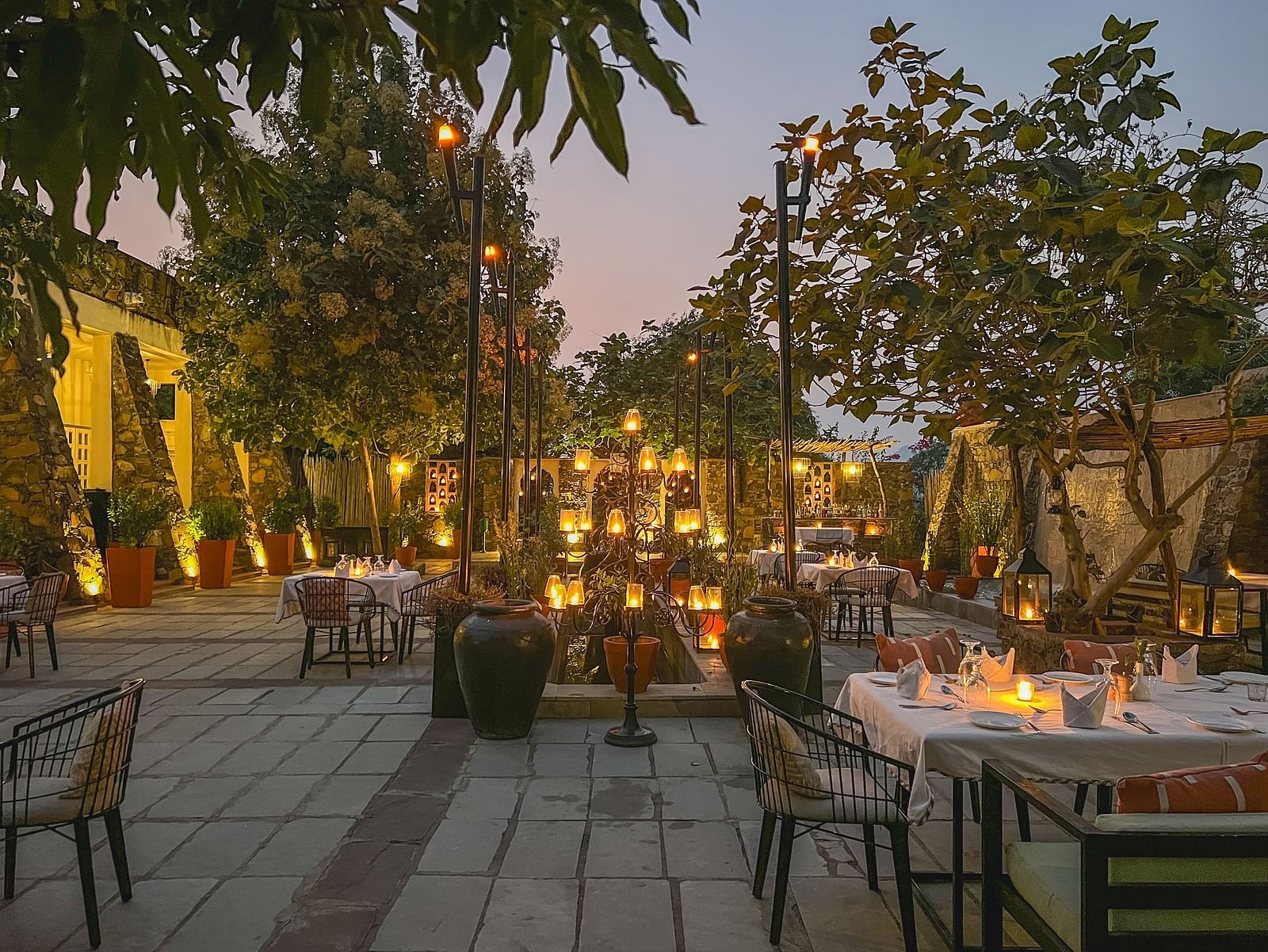 An image of an outdoor seating at the hotel with decorative lighting - Utsav Camp Sariska