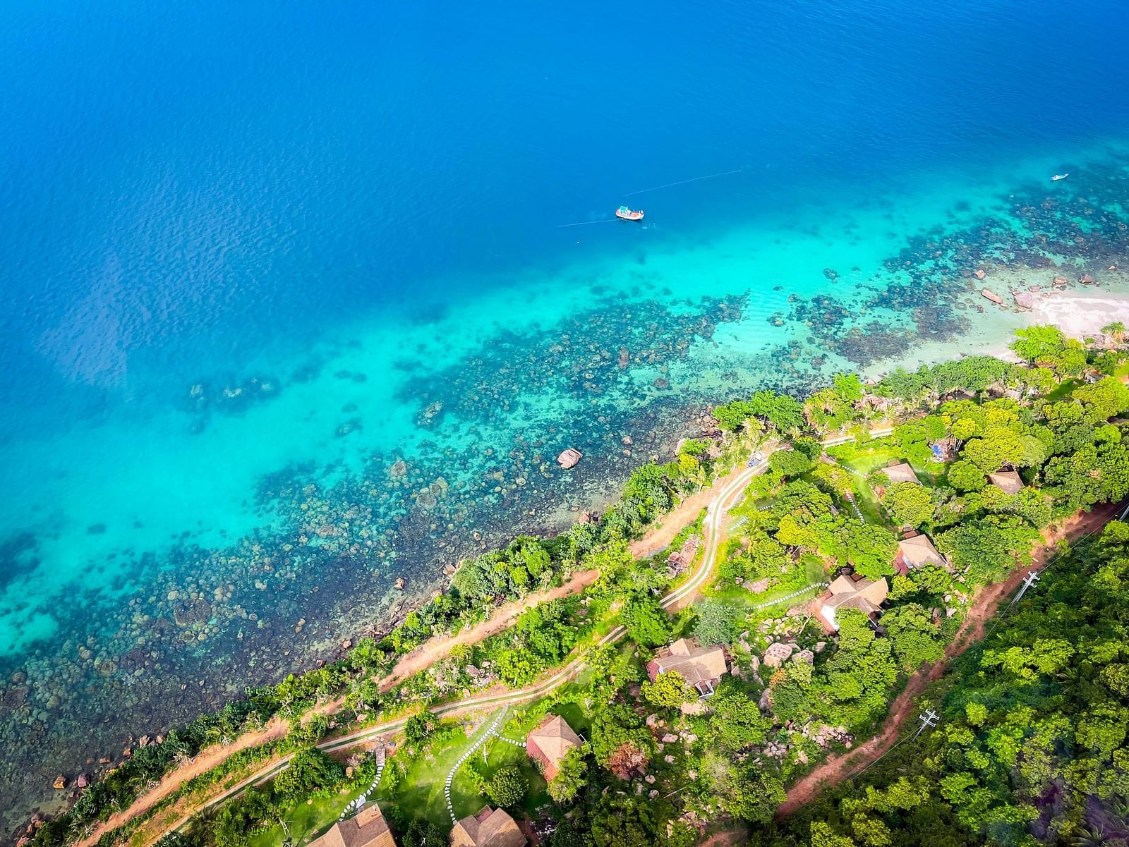 An aerial view of Phu Quoc with greenery on the lands, corals and blue water in view.