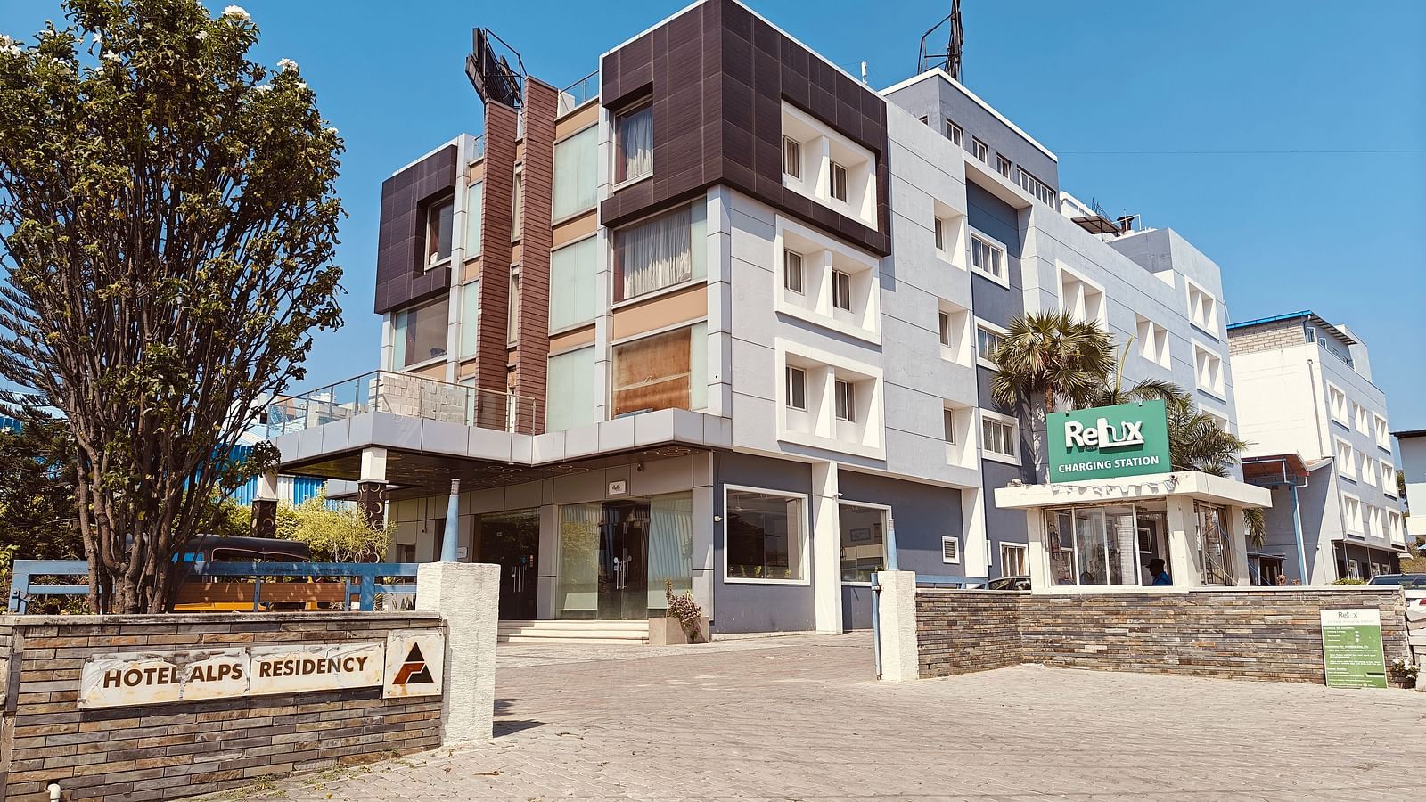 Exterior view of Hotel Alps Residency, Krishnagiri, with modern architecture and a spacious entrance.