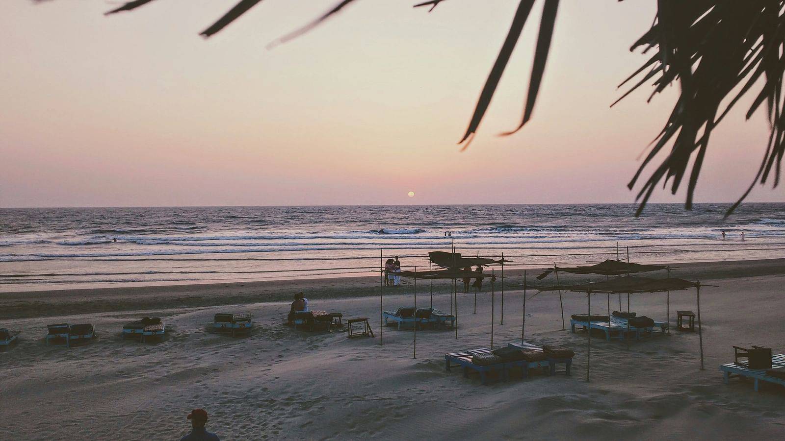 a sunset image of beach shacks by the beach