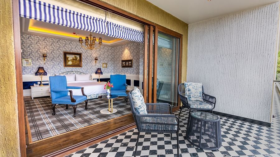 alt-text A hotel room with a large bed, comfy chairs and a balcony  - The Manor Luxury Hotel, Shimla