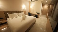 Superior King Room at Pride Elite Raipur featuring a plush king-sized bed with crisp white linens, subtle ambient lighting, a work desk, and sleek modern décor, creating a luxurious and comfortable atmosphere for guests.