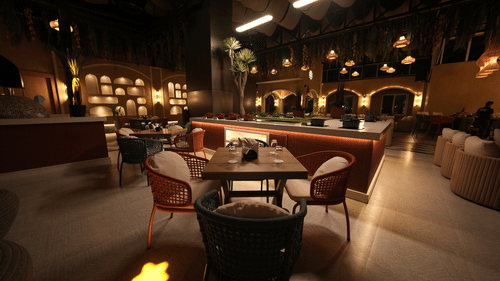 Stylish dining hall with modern lighting, round tables, and cushioned chairs at Pride Elite Raipur.