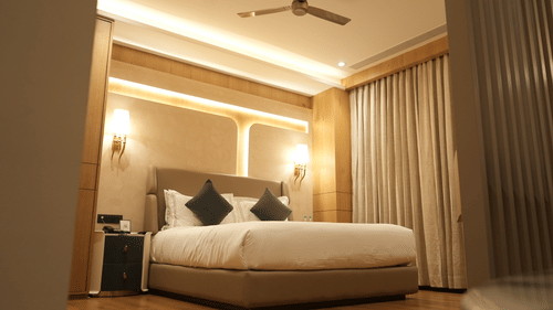 Spacious guest room with king size bed, warm lighting, and modern décor at Pride Elite Raipur.