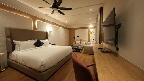 Stylish bedroom with king size bed, wall art, and modern lighting at Pride Elite Raipur.