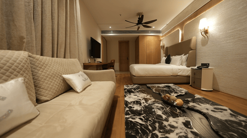 Cosy guest room with twin beds, modern furnishings, and bright interiors at Pride Elite Raipur.