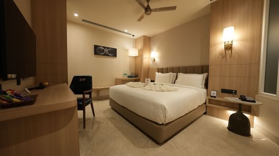 Comfortable room with seating area, modern furniture, and king bed at Pride Elite Raipur.