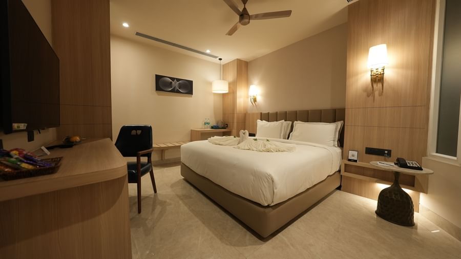 Comfortable room with seating area, modern furniture, and king bed at Pride Elite Raipur.