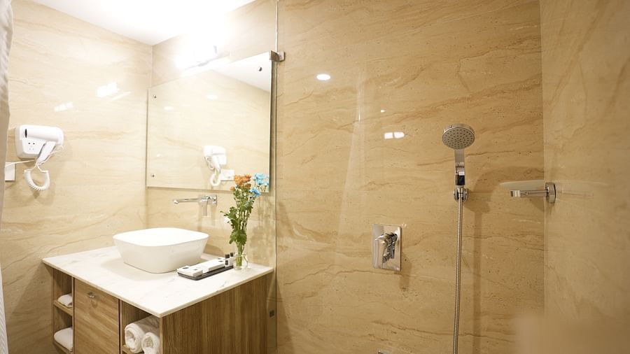 Well-lit bathroom featuring a wall-mounted sink, mirror, and walk-in shower at The Verda de Miranda Resort