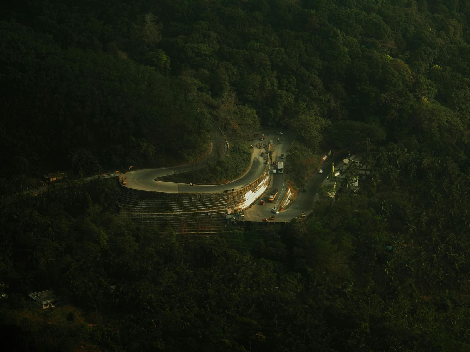 Long-shot view of a hairpin bend road surrounded by dense trees.