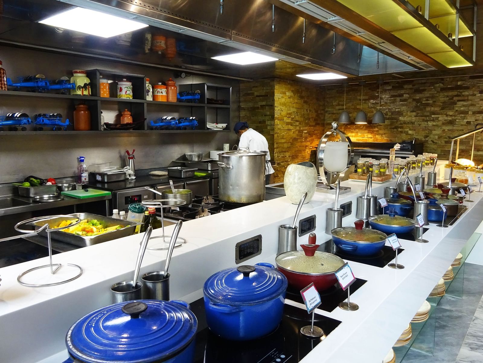 Modern kitchen setup with cooking utensils and ingredients at a buffet.