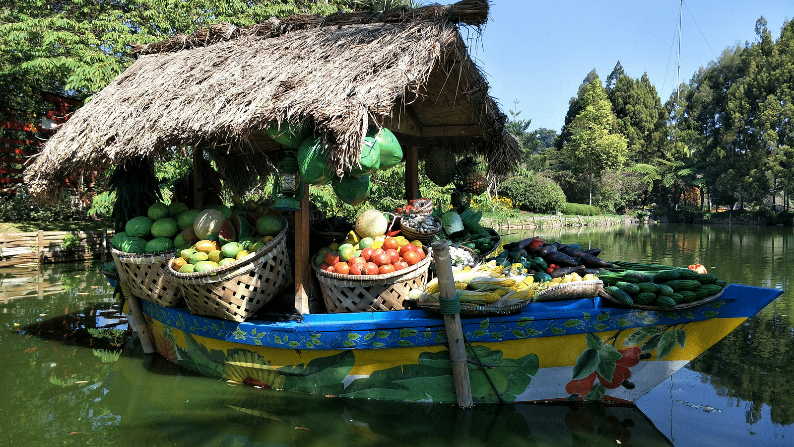 a boat filled with fruits and and veggies travelling on a waterbody.