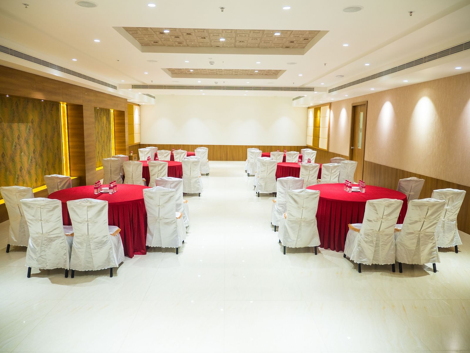 event hall with red tables and white satin chairs of ASR Parklane, Hosur