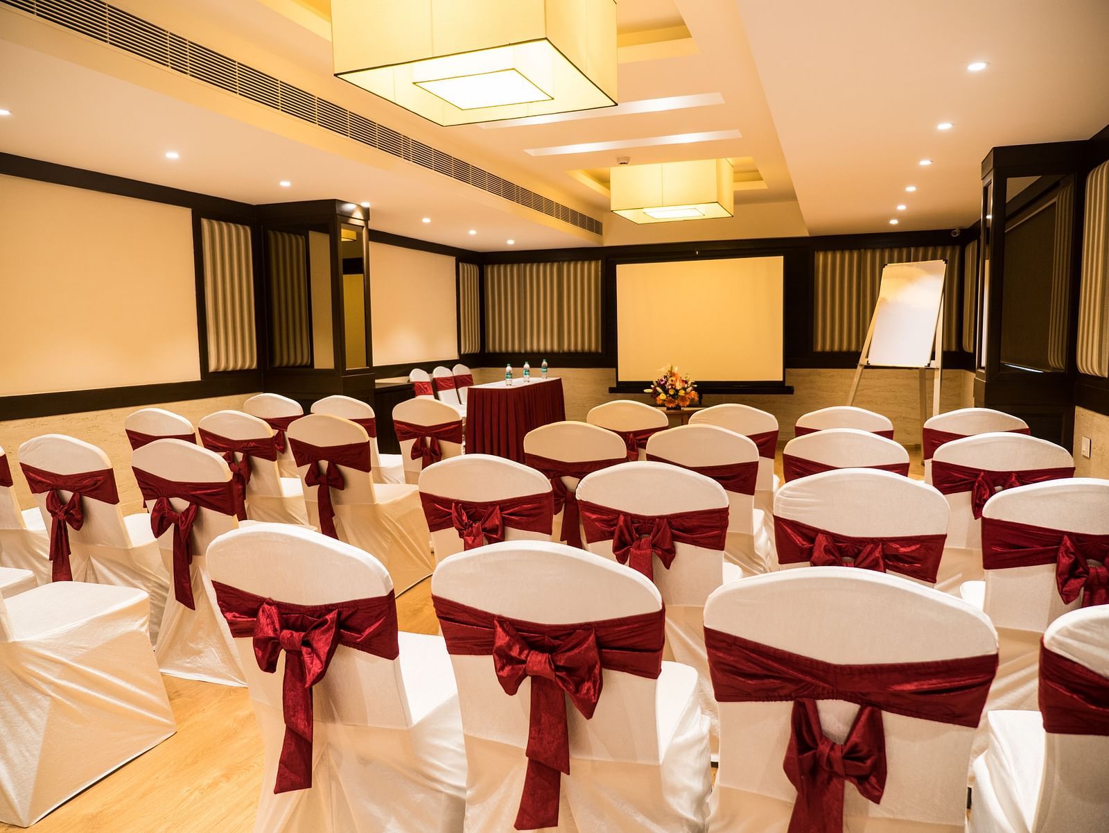 event hall with white satin chair and red ribbon of MM Legacy, Kanchipuram