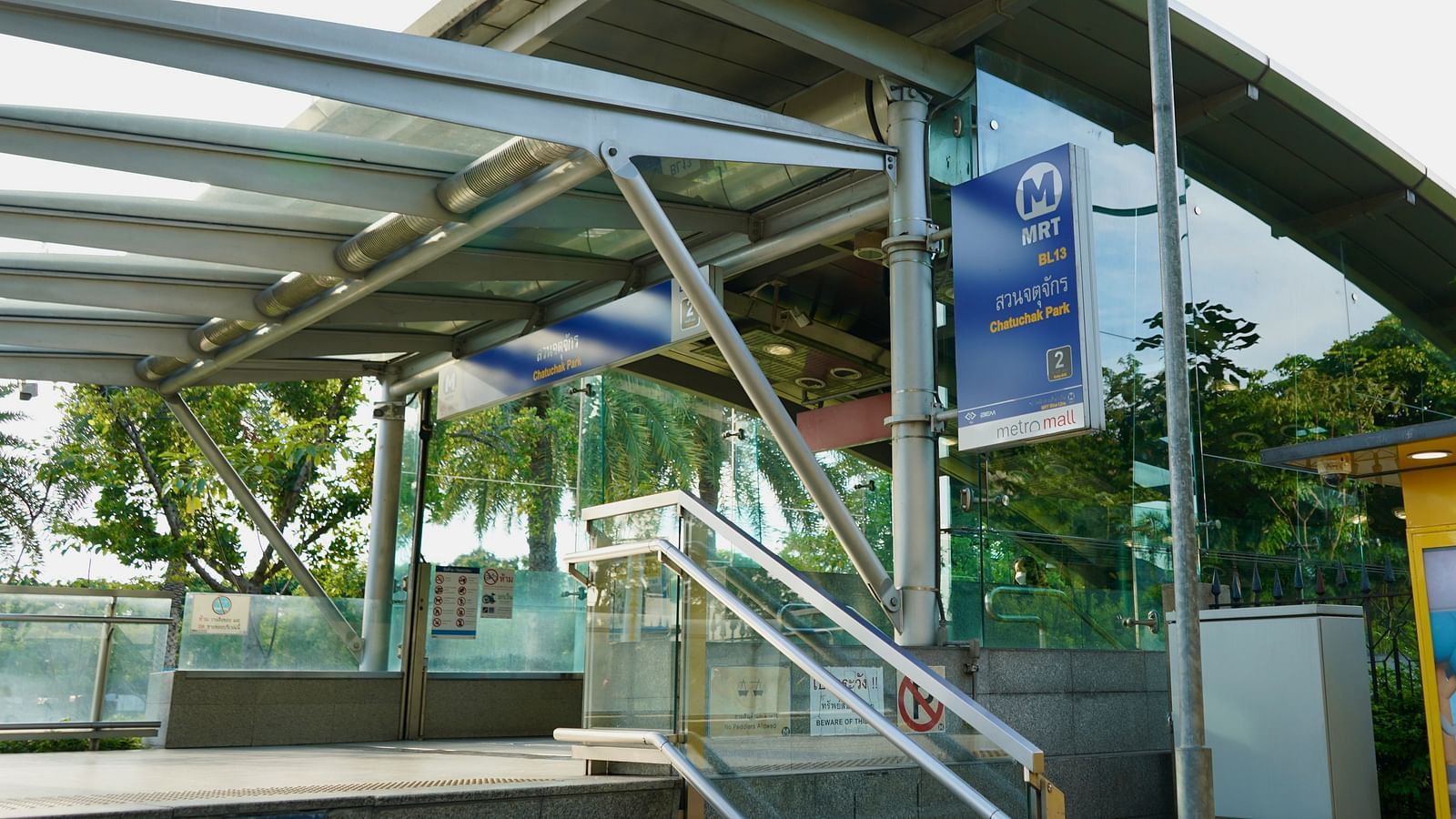 An overview of the entrance to the skytrain with a signage and steps in view.