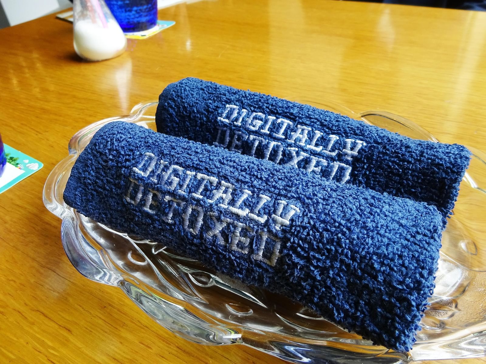 Blue towels with 'Digitally Detoxed' text rolled and placed in a bowl.