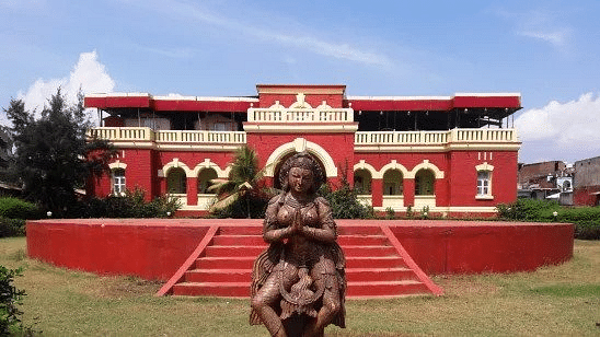 a red coloured temple with a goddess statue at the front