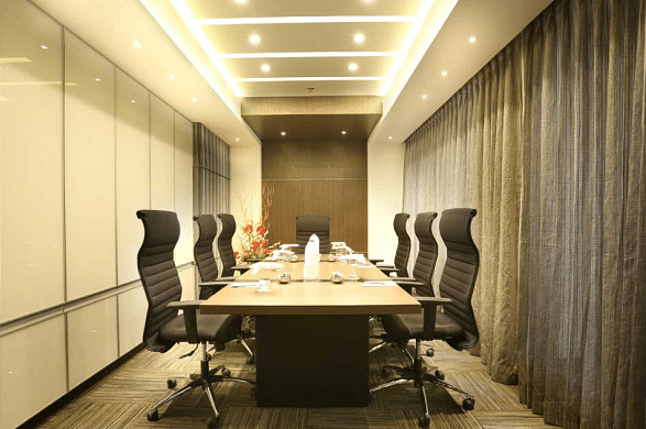  A modern conference room with a sleek table, leather chairs, and bright lighting, designed for professional meetings.