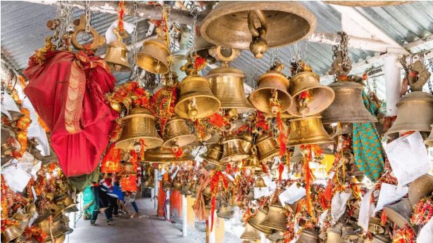An image showing lots of well decorated temple bells with ornamental designs hung on the roofing 