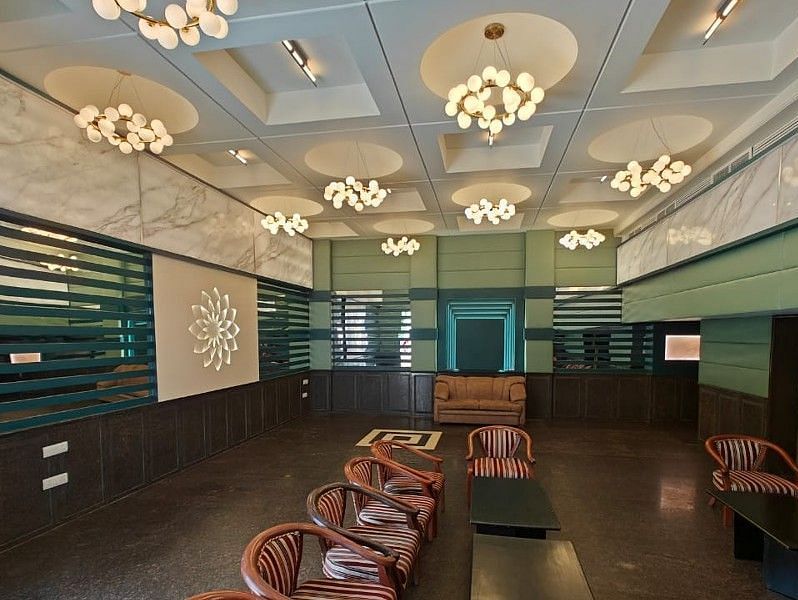 Full view shot of the Boardroom at Hotel Gold, Panipat with several brown coloured leather arm chairs arranged facing towards each other.