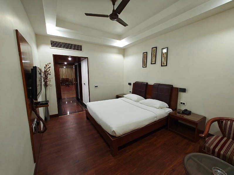 The bedroom of the Suite featuring a plush double bed with minimalist interiors - Hotel Gold, Panipat