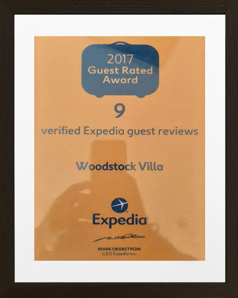 The image presents a '2015 Guest Review Awards' certificate from Expedia | Woodstock Resorts, Coorg